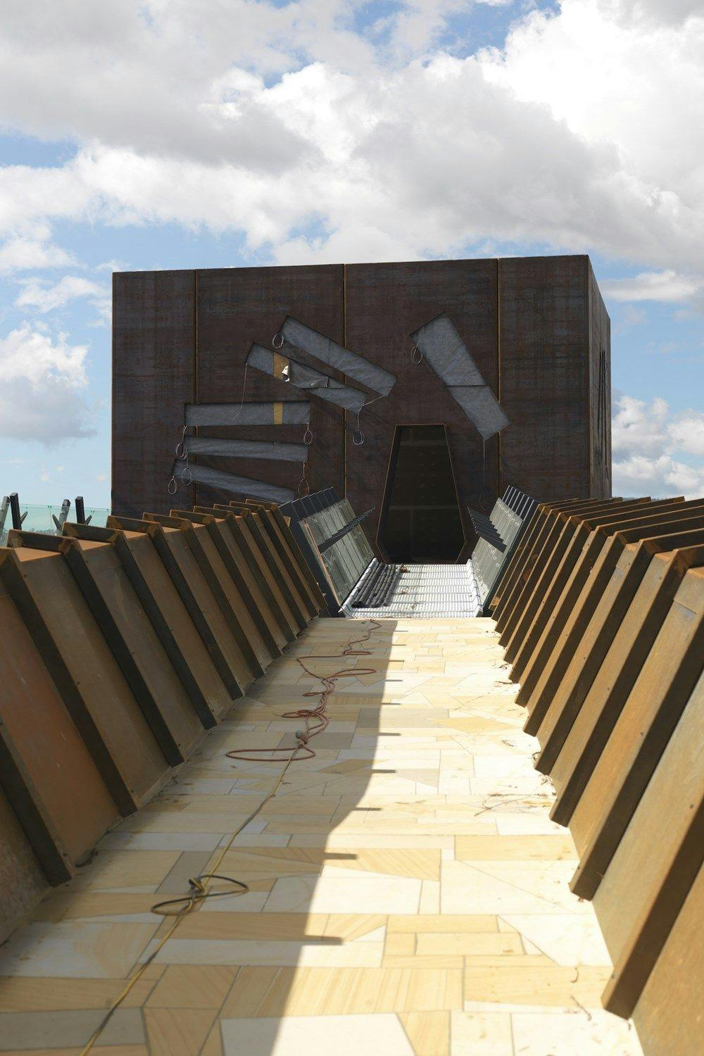 A sandstone path with corten steel leads to a square external room.